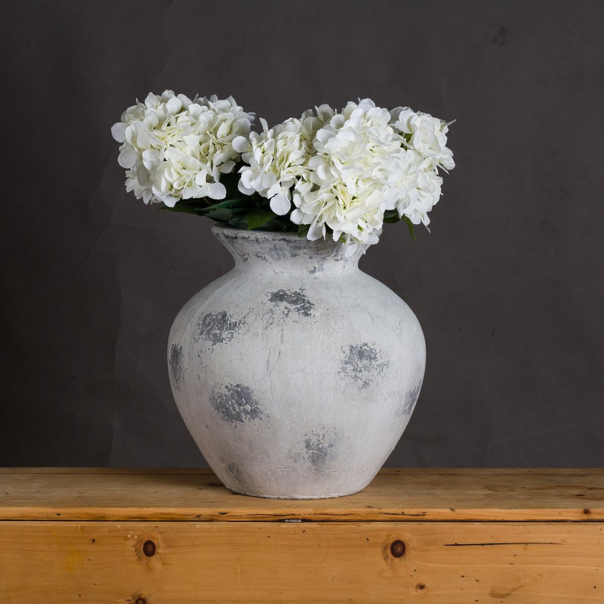 Downton Large Antique White Vase holding white hydrangea-style blooms on a wooden surface