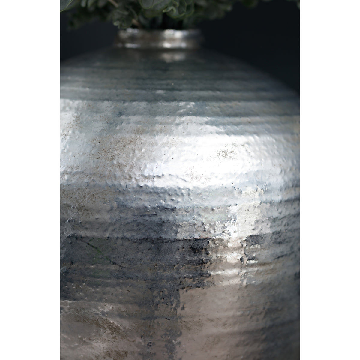 Detail of the reflective textured silver surface of the Astral Vase in a styled room
