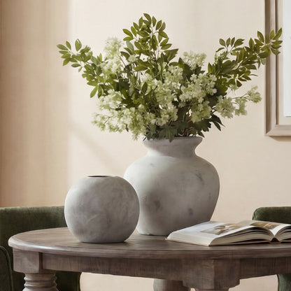 Darcy Antique White Vase at rear with white flowers and greenery beside a small round vase on a table