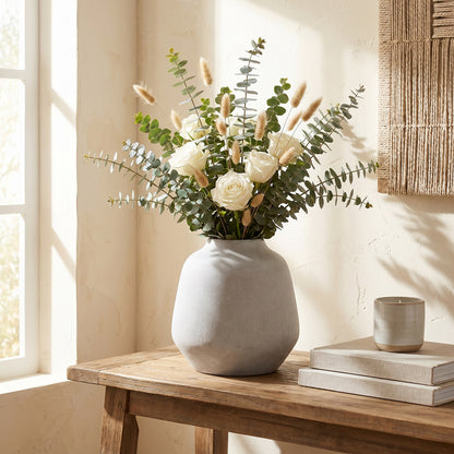 Darcy Ople Vase holding white roses and leafy stems on a wooden console