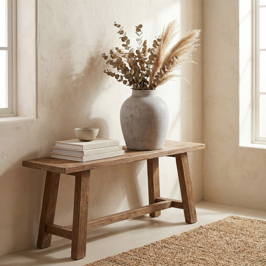 Darcy Stone Vase with dried grasses on a wooden bench in a sunlit neutral room