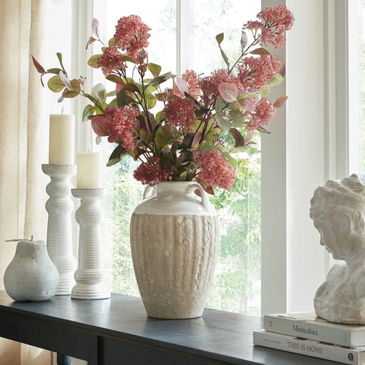 Thorne Large Amphora Vase with pink flower stems on a console beside white candle holders