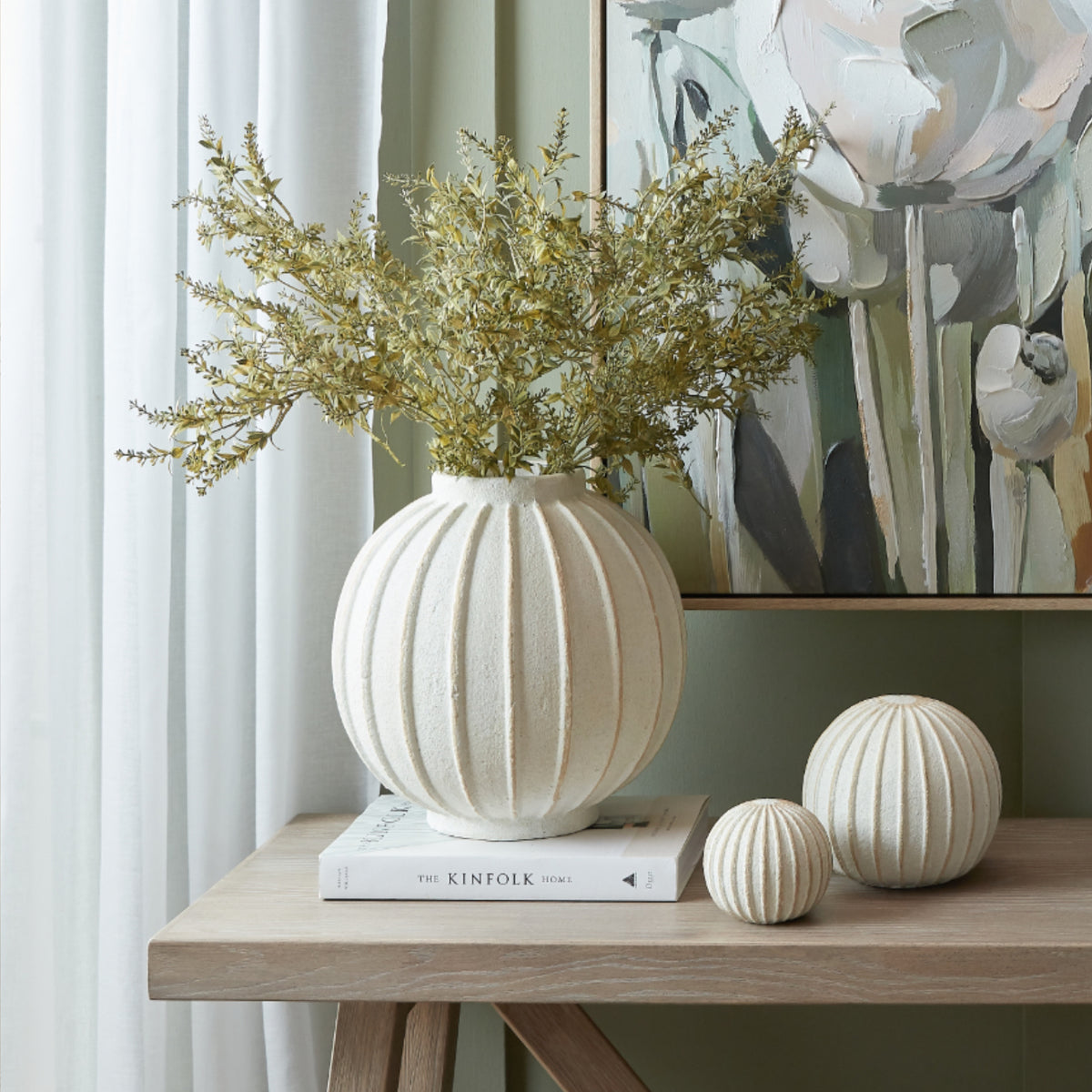 Grove Globe Vase with foliage on a console beside coordinating ribbed ornaments