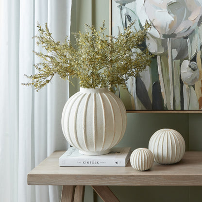 Grove Globe Vase with foliage on a console beside coordinating ribbed ornaments
