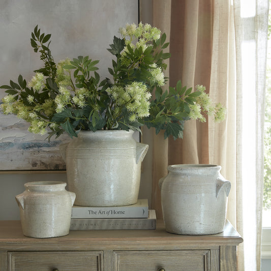 Tarn large handled pot at the centre of a three-pot display, styled with flowers beside a window